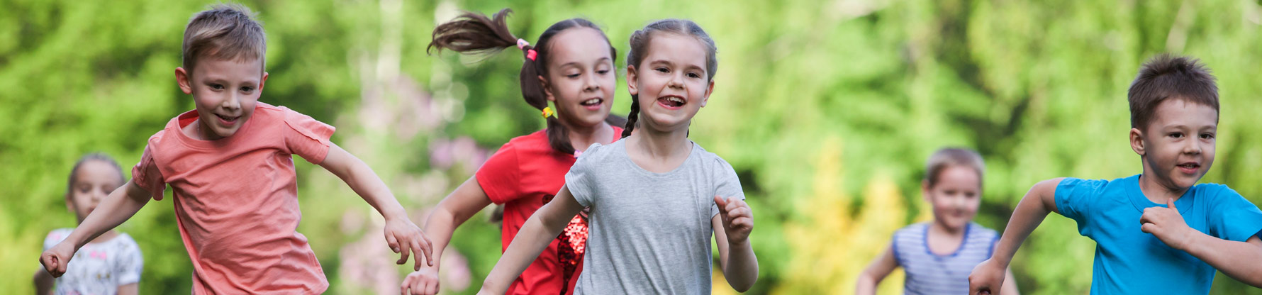 Eine Gruppe Kinder rennt auf einer Wiese