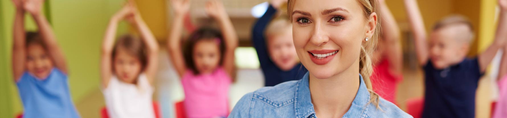 Eine Erzieherin steht vor Kindern in einem Stuhlkreis