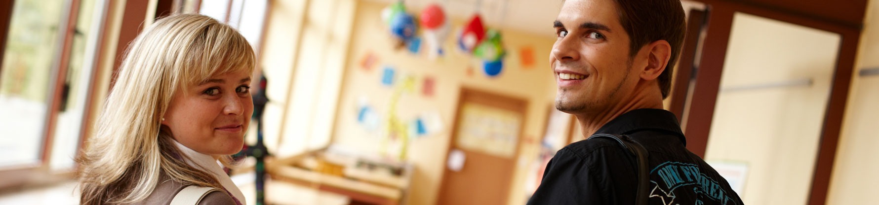 Eine Lehrerin und ein Lehrer auf dem Weg zum Unterricht im Gebäude