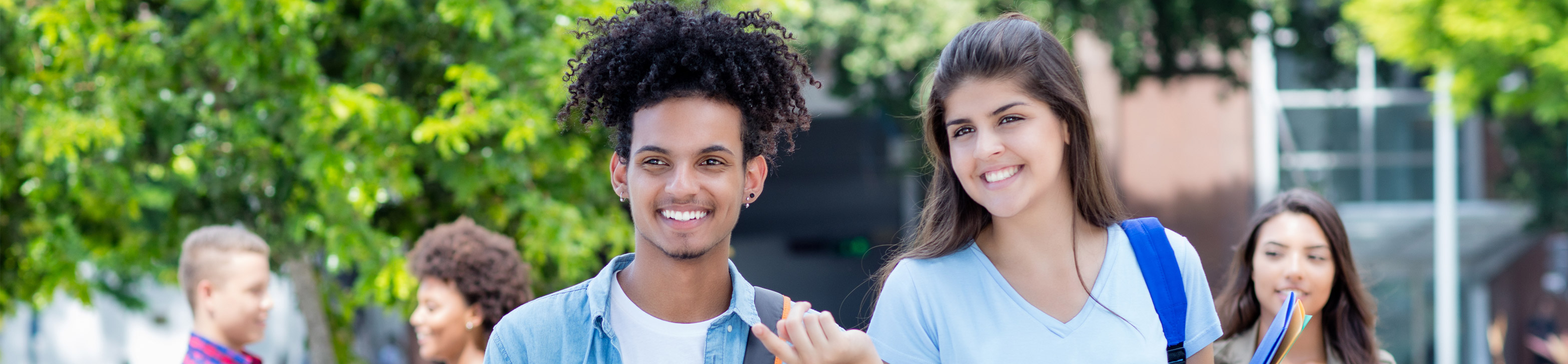Ein junger Mann und eine junge Frau gehen zusammen über den Pausenhof und lachen